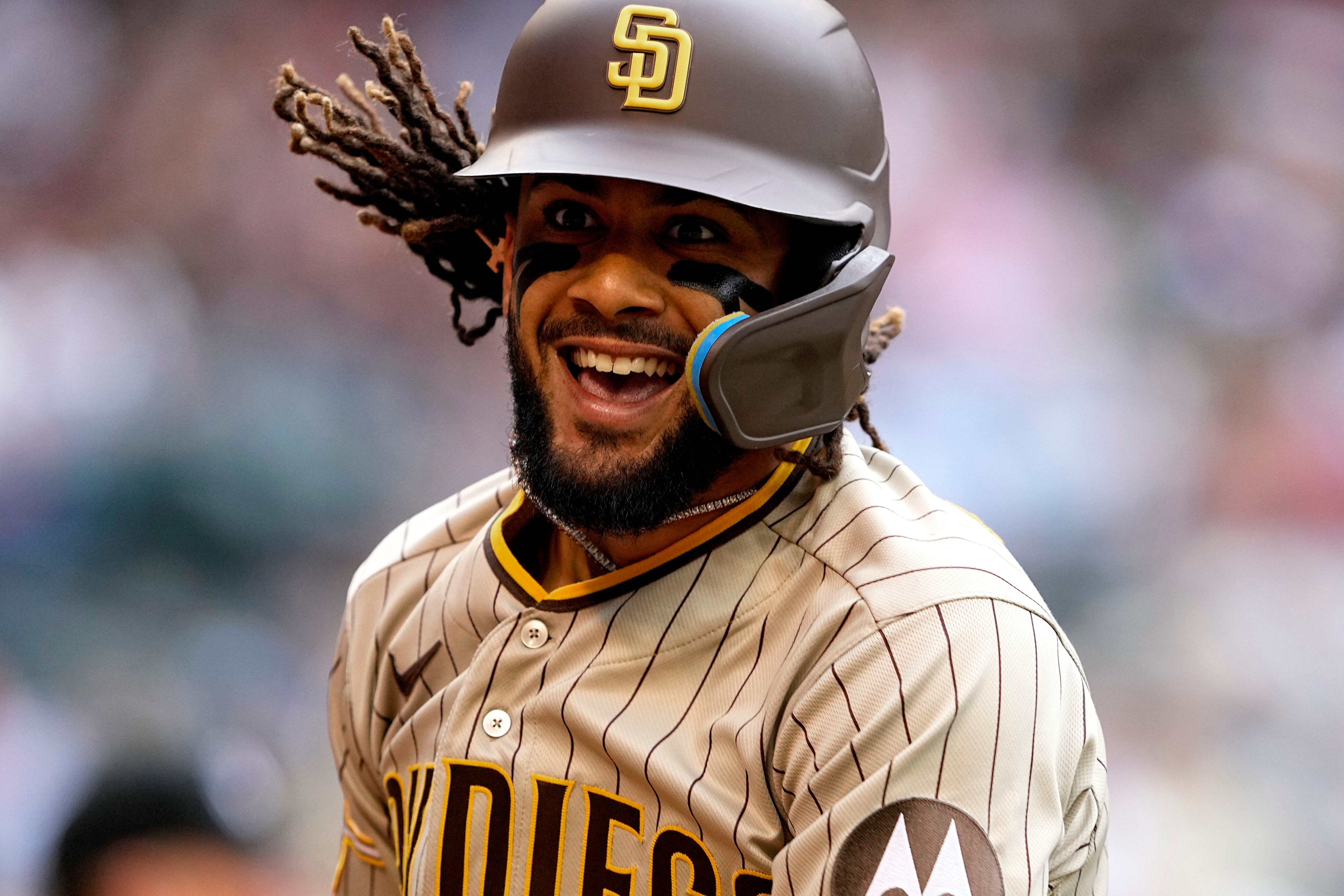 Fernando tatis jr in a padres jersey celebrating with a world