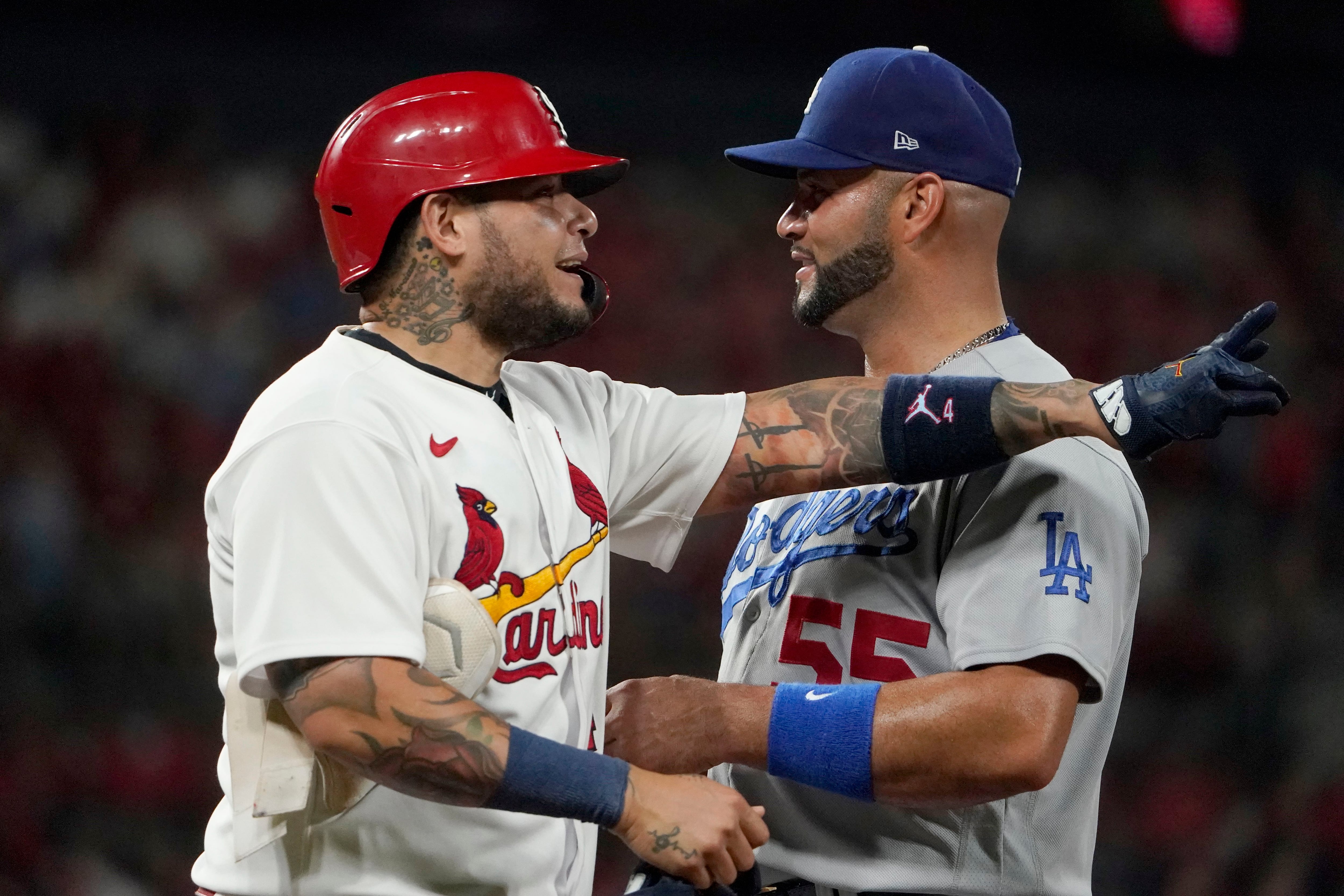 St. Louis Cardinals' Yadier Molina (4) gets a hug from former